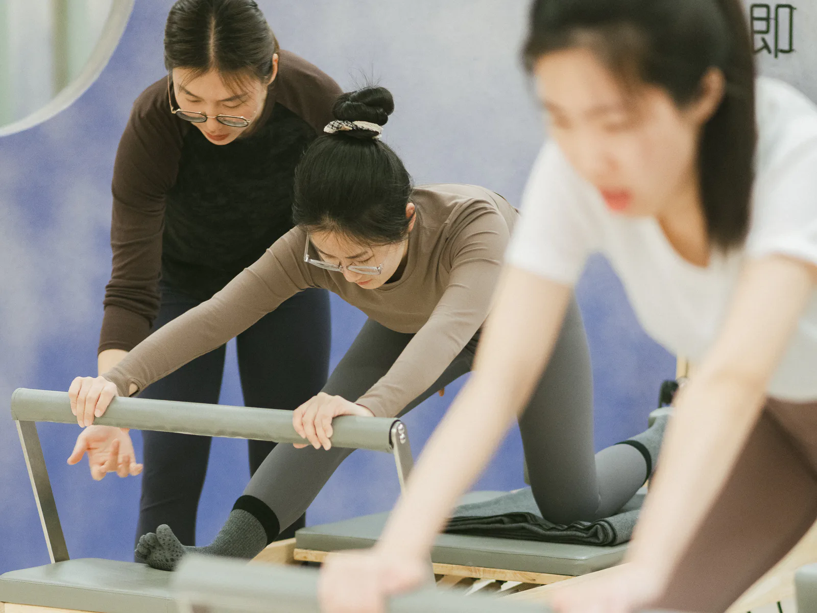 若瑜老师在小班课中观察并指导学员完成器械动作